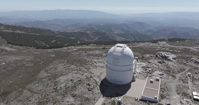 Aerial drone shot of Calar Alto Observatory telescope in the Sierra de Los Filabres mountain range in Almeria, Andalusia, Spain. Largest astronomical observatory in Europe. Sunny, clear blue sky 