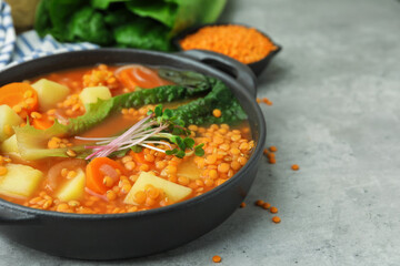 Tasty lentil soup in bowl on grey table, closeup. Space for text