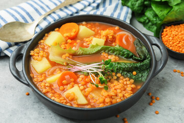 Tasty lentil soup served on grey table, closeup