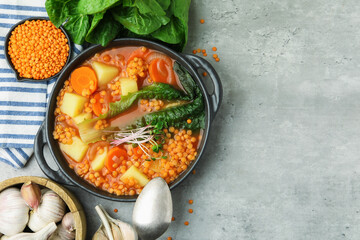 Tasty lentil soup served on grey table, flat lay. Space for text