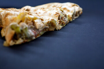 Macro close-up of the sliced edge of a grilled shawarma or durum wrap, showcasing the meat and vegetable filling with a sharp foreground and ample dark copy space