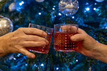 A close up of hands holding glasses in a celebratory toast, with selective focus