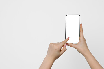 Woman holding smartphone with blank screen on light background, closeup. Mockup for design