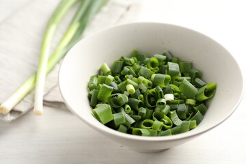 Fresh ripe green onions on white wooden table, closeup