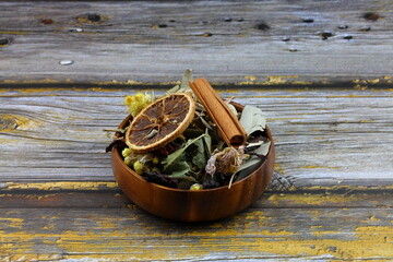 Winter tea for health in cold weather. Flavored with ginger, cinnamon, hibiscus, and orange. Isolated on woodenn background