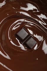 Tasty melted chocolate and piece as background, above view