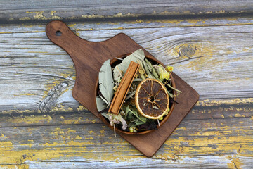 Winter tea for health in cold weather. Flavored with ginger, cinnamon, hibiscus, and orange. Isolated on woodenn background