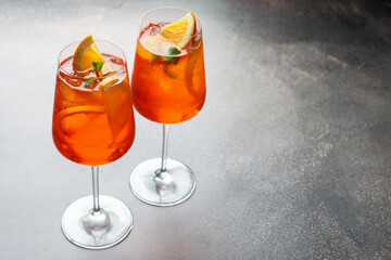 Glasses of refreshing spritzer cocktail on grey table. Space for text