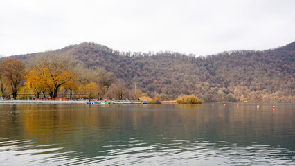 Nohur Lake autumn reflections - Calm waters of Nohur Lake reflecting autumn trees and surrounding hills under overcast skies. Nohur Lake, Azerbaijan