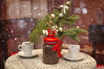 Christmas table with two cups of coffee, holiday decor, Christmas tree branch and coffee jar with red lid. Vintage Christmas