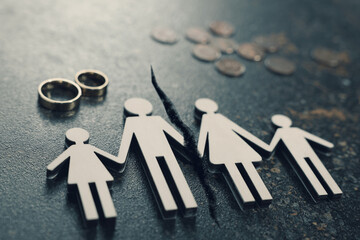 Divorce and alimony concept. Family figure with crack between wife and husband on table
