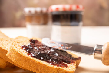 Jam jars, a rustic white table with toast and jam jars, selective focus.
