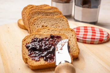Jam jars, a rustic white table with toast and jam jars, selective focus.