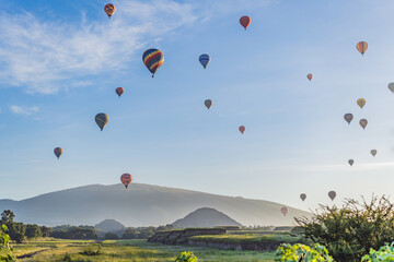 Colorful hot air balloons floating over Teotihuacan in Mexico, creating a breathtaking view of the ancient pyramids. Tourism, adventure, and cultural heritage concept