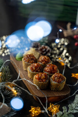 Colorful sushi rolls topped with savory ingredients rest on a wooden board, surrounded by glowing fairy lights and seasonal decorations, creating a cozy and inviting atmosphere for dining