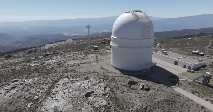 Isolated aerial drone shot of Calar Alto Observatory astronomy telescope in the Sierra de Los Filabres mountain range in Almeria, Andalusia, Spain. Largest observatory in Europe. Sunny, clear blue sky