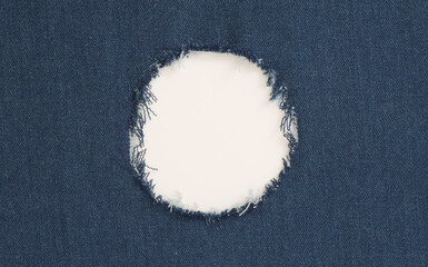 Grunge blue canvas denim fabric with crumpled torn circle frame. Texture abstract background.
