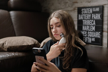 Casual Evening Skincare Routine With Microcurrent Device On Comfortable Sofa In Warm Lighting