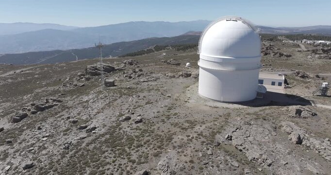 Isolated aerial drone shot of Calar Alto Observatory astronomy telescope in the Sierra de Los Filabres mountain range in Almeria, Andalusia, Spain. Largest observatory in Europe. Sunny, clear blue sky
