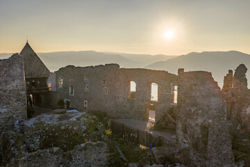 Visegrad, Hungary - Aerial panoramic drone view of the beautiful high castle of Visegrad on a moody autumn sunset. Danube Bend (Dunakanyar) and amazing golden sunset at background.