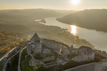 Visegrad, Hungary - Aerial panoramic drone view of the beautiful high castle of Visegrad on a moody autumn sunset. Danube Bend (Dunakanyar) and amazing golden sunset at background.