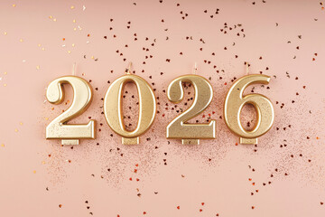 2026 gold candles on pastel background with glitter and heart confetti flat lay top view New Year copy space