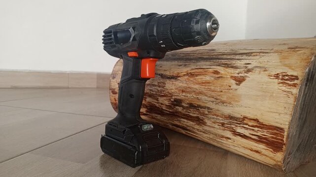 3/4 still image of a cordless impact screwdriver next to a wooden log
