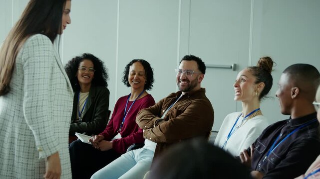 A group of engaged professionals actively participates in a conference, showing positive reactions and laughter. They are enjoying the presentation, fostering a collaborative learning environment.