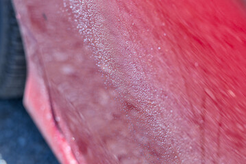 Fototapeta premium Water Droplets Forming On The Surface Of A Red Automobile Exterior.