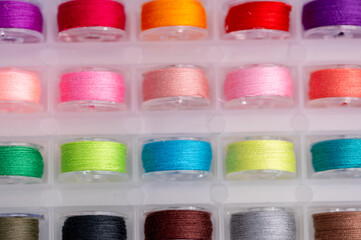 Spools of thread arranged in a clear storage container