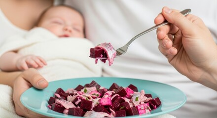 Caucasian female holding sleeping baby while eating beet salad with creamy dressing