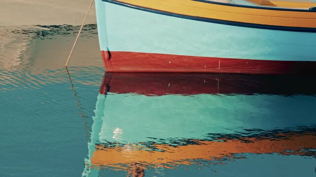 Abstract reflection of colorful boat hulls rippling across the surface of the water, creating a painterly effect