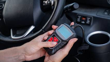 Woman using OBD2 diagnostic scanner.
