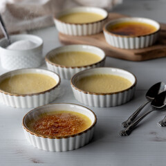 Ramekins filled with Creme Brulee with two having torched sugar on top.