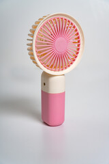 A small hand-held fan for personal use. On white background.