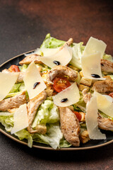 Fresh chicken caesar salad with parmesan slices