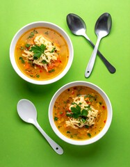 Two bowls of soup on green