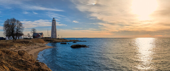 The historic New Haven Lighthouse, aka Five Mile Point Light, a 70-foot sandstone sentinel built in 1847, at the entrance to New Haven Harbor, in East Rock, New Haven, Connecticut, USA, at sunset