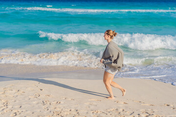 Woman enjoying peaceful time at the beach, relaxing on the sand with ocean views and warm sunlight. Summer leisure, wellbeing and travel concept, representing freedom, calmness and mindful coastal