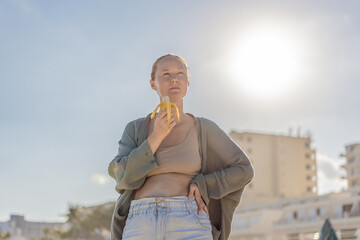 Woman enjoying peaceful time at the beach, relaxing on the sand with ocean views and warm sunlight. Summer leisure, wellbeing and travel concept, representing freedom, calmness and mindful coastal