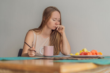 Woman enjoying a peaceful breakfast at the table in a bright home interior, starting her morning with calm energy. Healthy lifestyle, morning routine and wellbeing concept, representing self-care