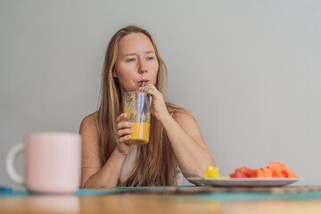 Woman enjoying a peaceful breakfast at the table in a bright home interior, starting her morning with calm energy. Healthy lifestyle, morning routine and wellbeing concept, representing self-care