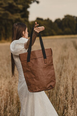 Young Boho Style Woman Holding Ecological Brown Washpapa Tote Bag in Grain Field During Summer Golden Hour
