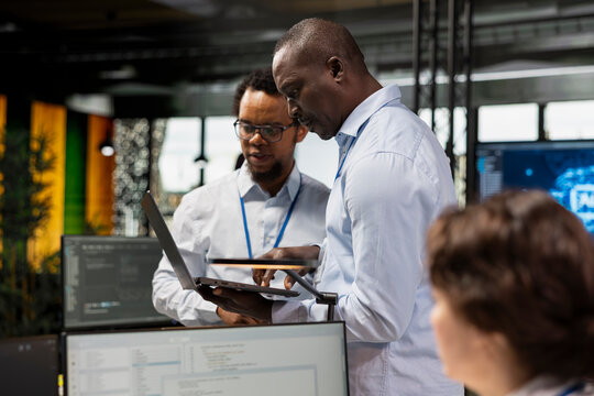 Engineering team testing AI machine learning algorithms at work using laptop. IT professionals scaling productivity with artificial intelligence large language model technology
