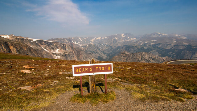 A sign along the Beartooth Highway that says Bear's Took with the mountains in the background.