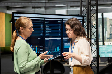 Goals oriented businesswomen dive deep into financial reports, leveraging graphs and indicators of corporate data to guide next strategic move with confidence. Company management.