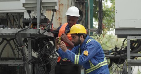 Telecom engineer and technician inspect communication equipment during network maintenance and upgrade operation. Infrastructure inspection, troubleshooting, cable management for reliable connectivity