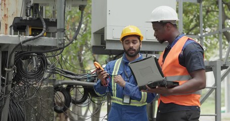 Telecom engineer and technician inspect communication equipment during network maintenance and upgrade operation. Infrastructure inspection, troubleshooting, cable management for reliable connectivity