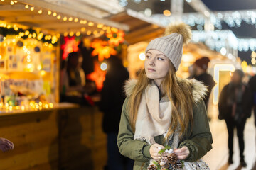 Girl walks through New Years open air market and stares at attractive goods and souvenirs. She is...