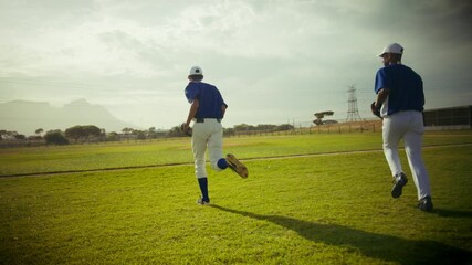 A focused baseball team huddles, then high-fives with camaraderie before players run across the field, ready for the game. Emphasizes teamwork and athletic preparation. - Powered by Adobe